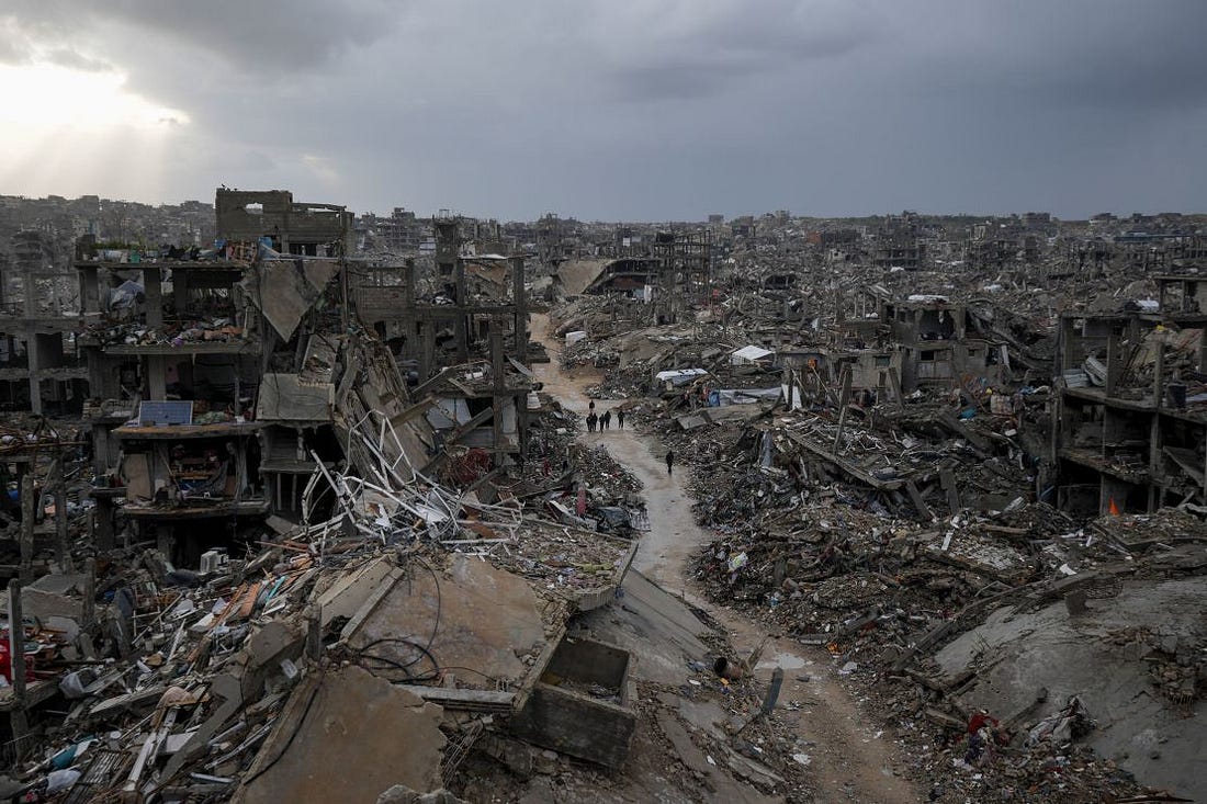 Palestinians walk through destruction caused by the Israeli air and ground offensive in Jabalya, Gaza, on February 6.